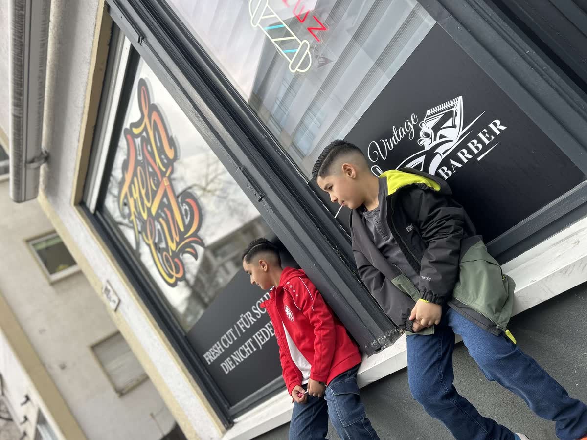 Schaufenster von FreshCut Darmstadt mit Logo und Barber-Pole von der Straße aus